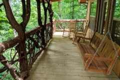 Back deck complete with porch swing and rocking chairs